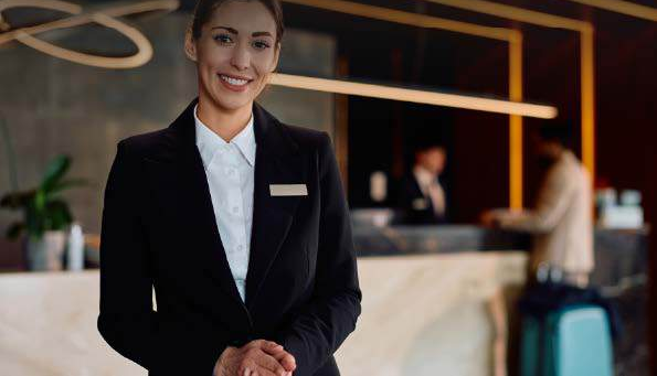 A smiling hotel receptionist standing in the lobby
